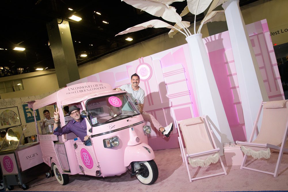 studio dado booth featuring a pastel pink colour scheme and an ice cream van with two male employees hanging out of the windows smiling at the camera and posing